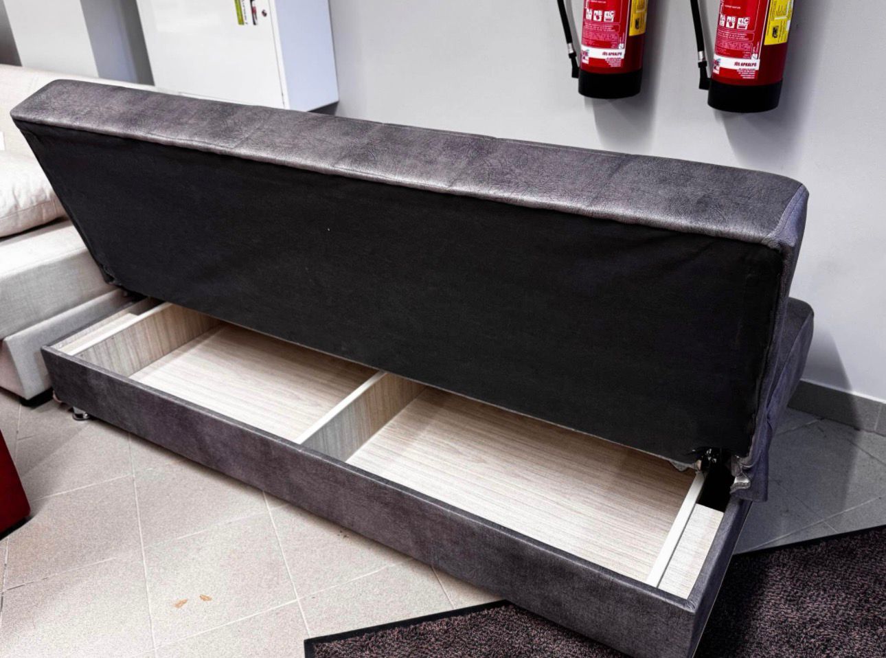Tumši pelēks dīvāns ar guļamo funkciju un veļas kasti